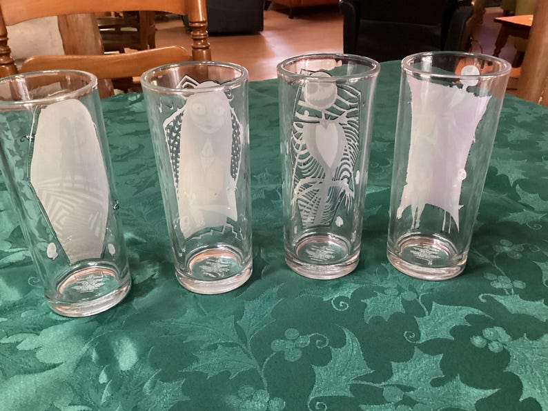 Puede incluir: Un juego de cuatro vasos transparentes, cada uno con una ilustraci&oacute;n blanca grabada distinta de personajes de Pesadilla antes de Navidad. Los dise&ntilde;os incluyen a Sally, Jack Skellington y otras figuras de la pel&iacute;cula, todos en un estilo esmerilado.