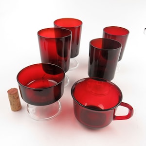 Può includere: Set di sei bicchieri di vetro rosso con base in vetro trasparente. Il set include una tazza di vetro rosso con manico.