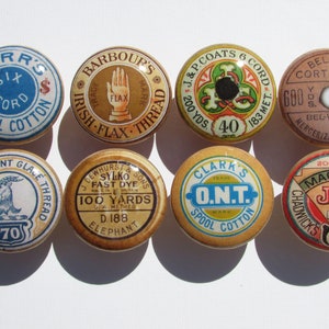 May include: Eight vintage spools of thread with colorful labels and branding. The spools feature various designs, including a hand, a goat, a clover, and a machine. The labels include text such as "Kerr's Six Cord Spool Cotton", "Barbour's Irish Flax Thread", "J & P Coats 6 Cord", "Belding Corticelli", "Brooks Patent Glacé Thread", "J Dewhurst & Sons Sylko Fast Dye", "Clark's O.N.T. Spool Cotton", and "Chadwick's Machine J & C Bro 60 Six Cord".