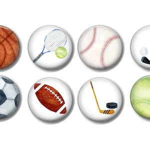 May include: Eight round buttons with different sports equipment illustrations. The buttons are white with a black outline. The sports equipment includes a basketball, tennis racket and ball, baseball, golf club and ball, soccer ball, football, hockey stick and puck, and a tennis ball.