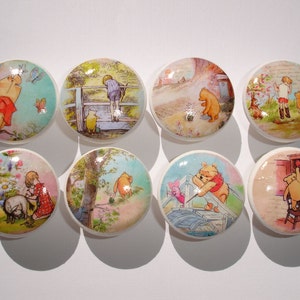 May include: Eight round ceramic knobs with Winnie the Pooh and friends designs. The knobs feature various scenes from the Winnie the Pooh stories, including Winnie the Pooh with Piglet, Winnie the Pooh with Tigger, Winnie the Pooh with Eeyore, and Winnie the Pooh with Christopher Robin.