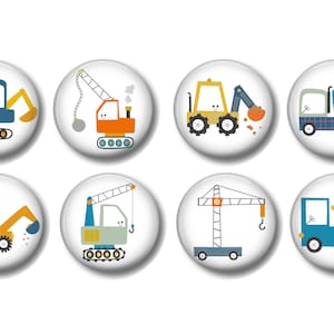 May include: Set of eight construction vehicle themed buttons. The buttons are round and white with a colorful cartoon image of a construction vehicle on each. The vehicles include a bulldozer, crane, cement mixer, and dump truck.