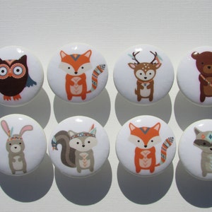 May include: Set of eight ceramic knobs featuring various woodland animals with tribal-inspired patterns. The animals include an owl, fox, deer, bear, rabbit, squirrel, raccoon, and another fox. The knobs are white with colorful animal illustrations.