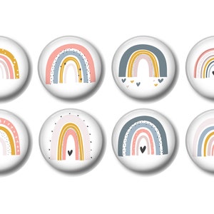 May include: Eight round, white, decorative magnets with different rainbow designs. Each magnet features a rainbow with different colors and patterns, including stars, hearts, and dots.