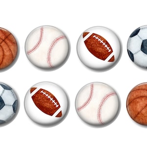 May include: Six round buttons with images of different sports balls. The buttons feature a basketball, baseball, football, and soccer ball. The buttons are white with a glossy finish.