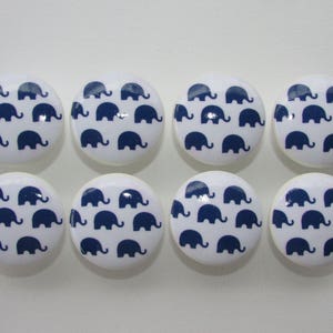 May include: Set of eight white ceramic knobs with a blue elephant pattern. Each knob features a repeating pattern of blue elephants on a white background.