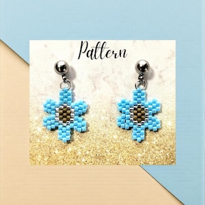 May include: A pair of dangle earrings featuring a flower-shaped beadwork design. The petals are light blue, the centre is brown, and the border is silver. The earrings hang from silver-toned metal ball studs. The word Pattern is printed above.