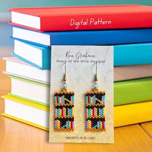 May include: A pair of rectangular beaded earrings featuring a bookshelf design with multi-colored books on black shelves. The earrings are displayed on a white card with the text Kim Graham Heart of the Hills Designs and Handcrafted in the Ozarks.