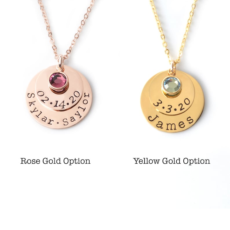 May include: Two gold necklaces with layered discs. The top disc has a small gemstone, and the bottom disc has engraved text. The left necklace is rose gold with a pink gemstone and the text "Skylar 02.14.20 Saylor". The right necklace is yellow gold with a blue gemstone and the text "James 3.3.20".