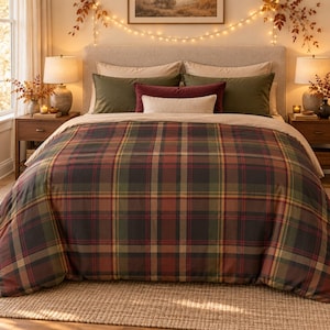 Puede incluir: Una cama con un edredón de cuadros en tonos verde oscuro, burdeos y beige. La cama está decorada con dos almohadas verde oliva, un cojín burdeos y un pequeño cojín rectangular de color crema frente a un cabecero de color beige.