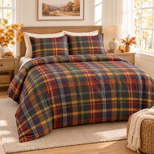 Puede incluir: Un juego de cama con un patrón de cuadros en tonos verde oscuro, rojo intenso, amarillo mostaza y azul marino. El conjunto incluye un edredón grande que cubre la cama y dos fundas de almohada rectangulares a juego con el mismo diseño.