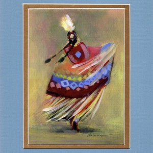 May include: An artistic painting of a Native American dancer in motion. The dancer wears a colorful dress with geometric patterns in red, blue, and yellow. The artwork is framed with a light brown mat and a blue border.