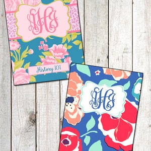 May include: Two floral patterned notebook covers with monogrammed initials in a pink and blue colour scheme. The top cover has a pink monogram and the text "History 101" printed on a white label. The bottom cover has a blue monogram.
