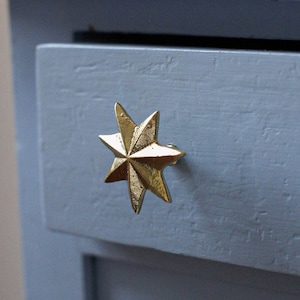 May include: A light blue drawer with a gold star-shaped cabinet knob.