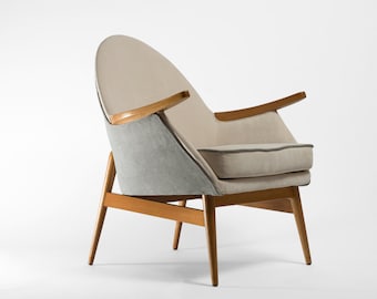 May include: A light gray and beige armchair with wooden arms and legs. The chair has a curved back and a comfortable seat.