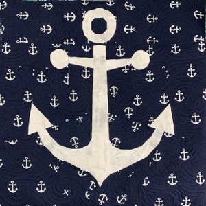 May include: A white anchor on a dark blue background with a repeating pattern of white anchors.