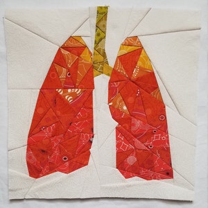 May include: A patchwork quilt block depicting a pair of lungs in red, orange, and yellow fabric. The block is made up of many small triangles and is set against a white background.