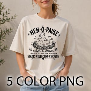Könnte beinhalten: Cremefarbenes T-Shirt mit dem Text "HEN-O-PAUSE" über einer Henne in einem Nest. Darunter steht "when a woman reaches a certain age and starts collecting chickens." Am unteren Rand des Shirts steht "5 COLOR PNG".