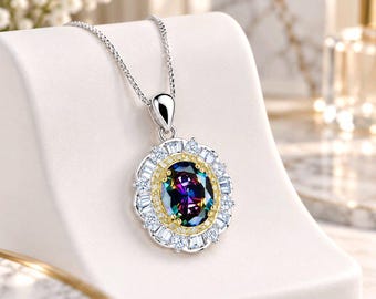 May include: A silver-toned necklace featuring an oval pendant with a central iridescent stone. The stone is surrounded by a thin gold-toned border, a ring of small clear stones, and an outer halo of baguette-cut clear stones on a silver chain.