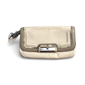 May include: Cream-colored leather clutch with a snakeskin accent and silver-tone hardware. The rectangular bag features a flap closure and a wrist strap. The edges are trimmed with a taupe color.