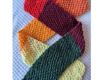 May include: A multi-colored knitted scarf with stripes of red, orange, yellow, green, and maroon.
