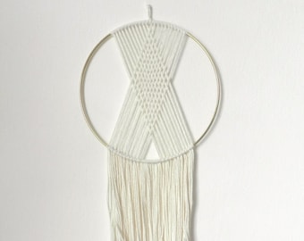 Modern macrame wall hanging, yarn crisscrossed on ring