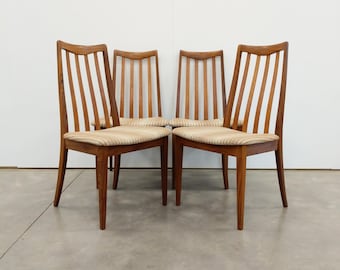 May include: Four wooden chairs with a mid-century modern design. The chairs have a light brown finish, vertical slat backs, and upholstered seats with a striped pattern. The chairs are arranged in a group, showcasing their design and style.