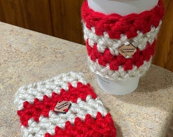 May include: Two crocheted coffee cup cozies in red and white with a wooden tag that says "Crocheted Goodness".
