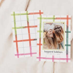 May include: Holiday greeting cards with a plaid pattern in green, red, and pink. One card features a photo of two people and the text "happiest holidays". The cards are on a white background.