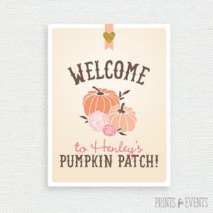 May include: A rectangular sign with a cream background features the word "WELCOME" in brown script above orange pumpkins and pink roses. The text "to Henley's PUMPKIN PATCH!" is below. A gold glitter heart decorates the top.