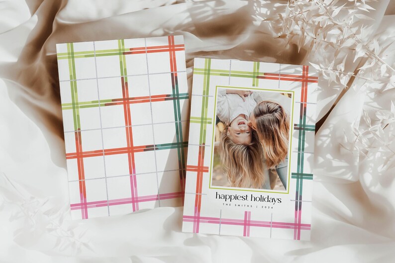 May include: Holiday greeting cards with a plaid pattern in red, green, and pink. One card features a family photo with the text "happiest holidays" and the family name. The cards are on a white background.