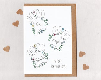 May include: A sympathy card with a handprint design and the words "Cry, Laugh, Remember" surrounded by flowers. The card also says "Sorry for your loss".