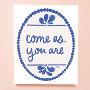 May include: A white card with a blue circle containing the text "come as you are" in blue cursive lettering. The circle is decorated with a blue beaded border and two blue floral designs.