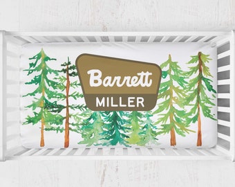Minky crib sheet with watercolor trees, baby name on national forest style sign. National Park themed baby nursery bedding. Hiking, camping