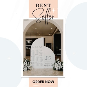Peut inclure: Un plan de table de mariage blanc avec un design en demi-cercle. Le tableau est intitulé "Nos personnes préférées" et liste les noms par ordre alphabétique. Le tableau est affiché dans une pièce avec une porte cintrée. Le texte "JG" est affiché sur une pancarte séparée en demi-cercle avec le texte "Bienvenue dans notre bonheur pour toujours".