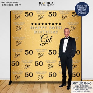 May include: Gold and black 50th birthday backdrop with the name Gil and the text "Happy 50th Birthday". The backdrop is decorated with gold stars and confetti. A man in a tuxedo is standing in front of the backdrop.