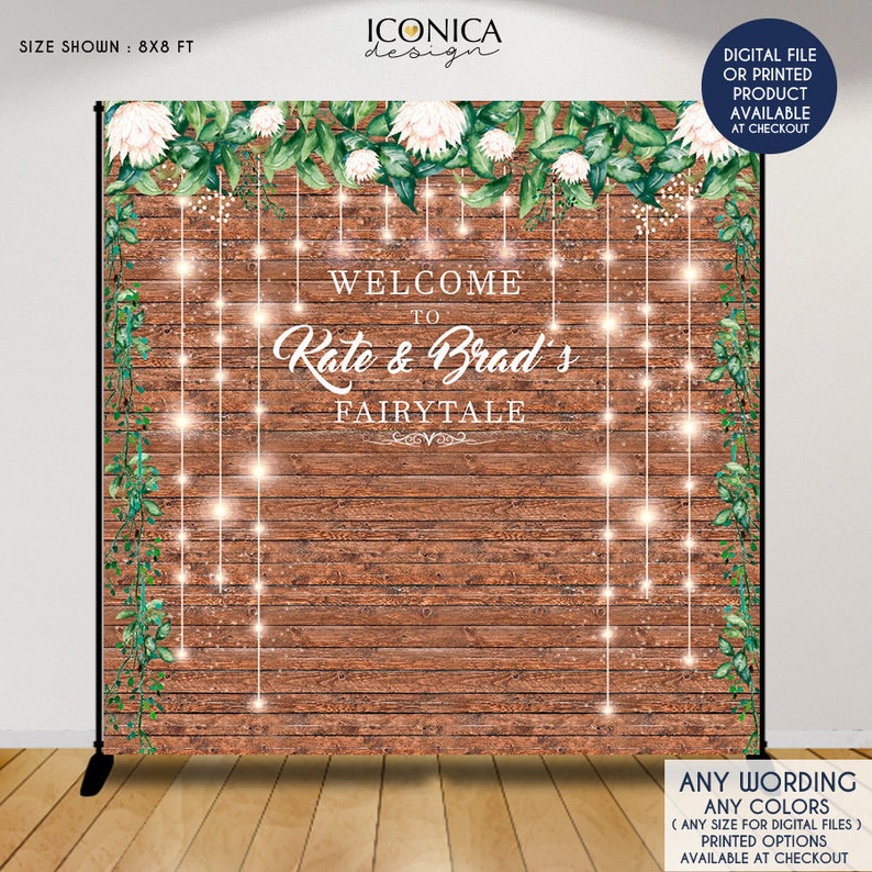 May include: A rustic wooden backdrop with greenery and white flowers. The text "Welcome to Rate & Brad's Fairytale" is written in white script. The backdrop is 8x8 feet.