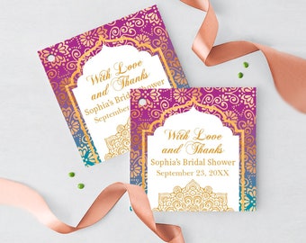 Peut inclure: Deux étiquettes carrées pour une fête prénuptiale avec un motif floral violet et doré. Les étiquettes ont un cadre blanc avec le texte "With Love and Thanks, Sophia's Bridal Shower, September 23, 20XX". Un ruban pêche et des confettis verts sont également dans l'image.