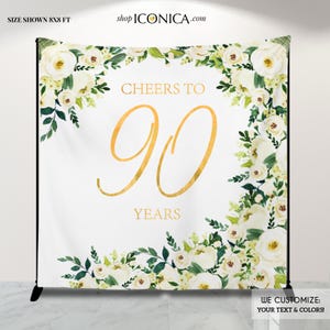 May include: White floral backdrop with gold text that reads "Cheers to 90 Years". The backdrop is 8x8 feet and can be customized with different text and colors.