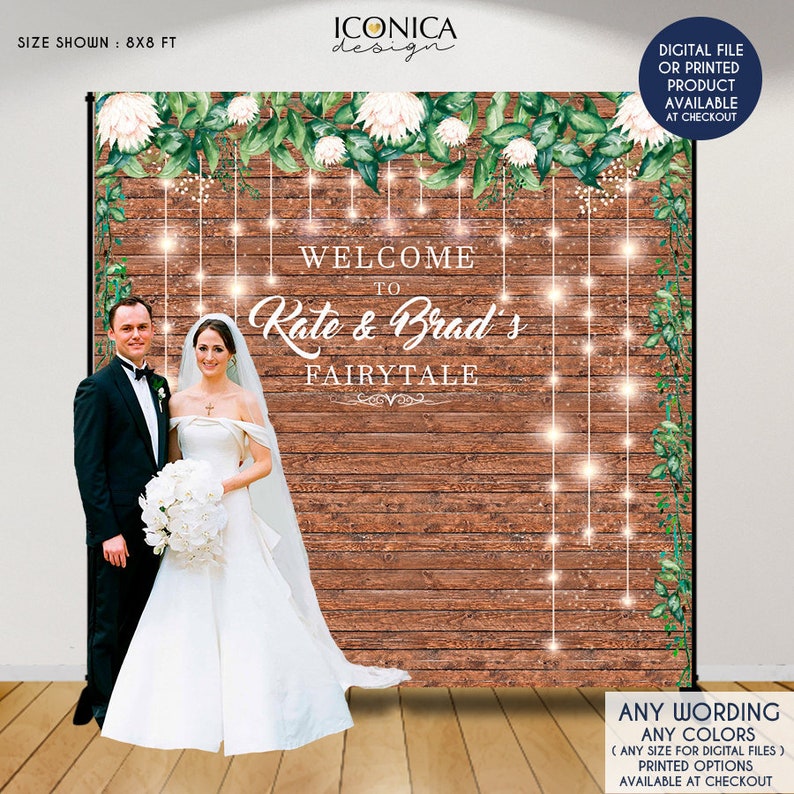 May include: A wedding backdrop with a rustic wooden background, white flowers, and greenery. The text "Welcome to Rate & Brad's Fairytale" is displayed in gold lettering. The backdrop is 8x8 feet.