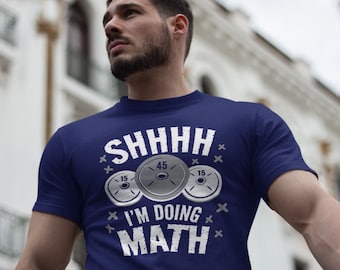 May include: A navy blue t-shirt with a white graphic of weight plates and the text "Shhhh I'm doing math".