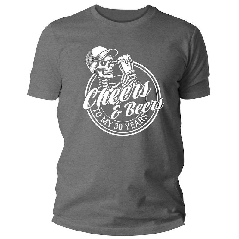 May include: A grey t-shirt with a white graphic. The graphic shows a skeleton wearing a cap and holding a beer mug, with the words "Cheers & Beers To My 30 Years" in a circular design.