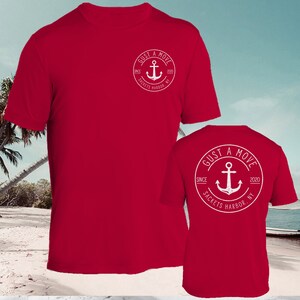 May include: Red t-shirt with a white circle logo featuring an anchor and the text "GUST A MOVE SINCE 2020 SACKETS HARBOR, NY".