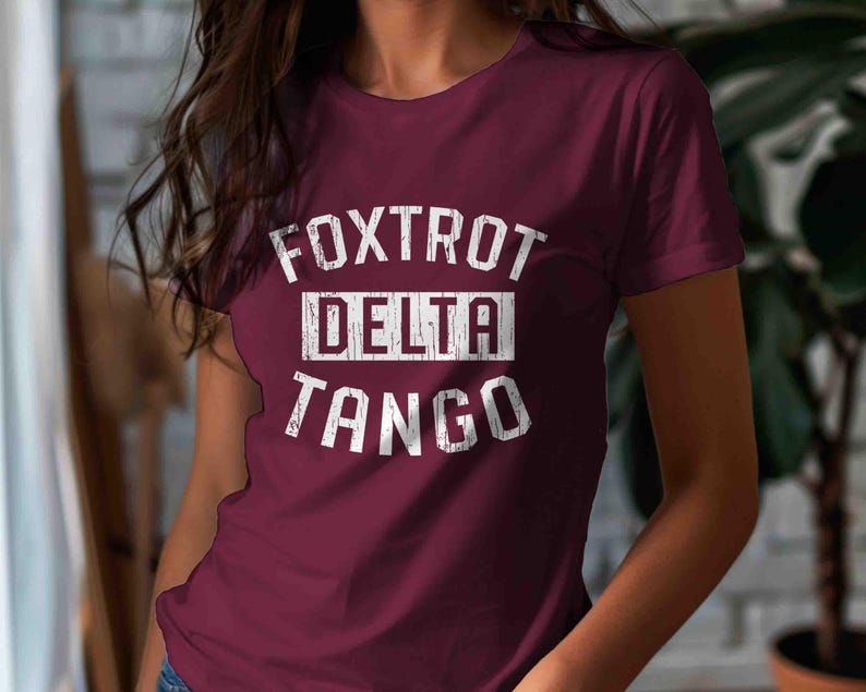 May include: A maroon t-shirt with white text that reads "FOXTROT DELTA TANGO".