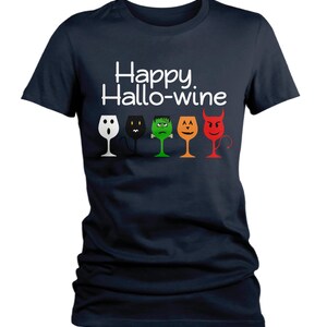 K&ouml;nnte beinhalten: Ein marineblaues T-Shirt mit dem Text "Happy Hallo-wine" und einer Reihe von f&uuml;nf Weingl&auml;sern mit verschiedenen Halloween-Charaktergesichtern. Die Gl&auml;ser sind wei&szlig;, schwarz, gr&uuml;n, orange und rot.