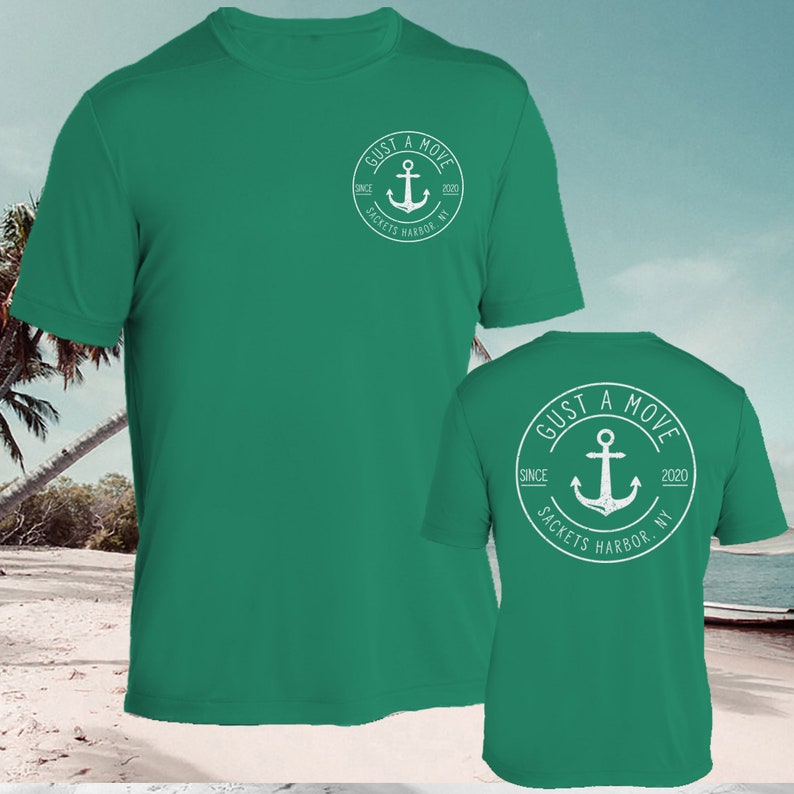 May include: A green t-shirt with a white circle logo on the front and back. The logo says "GUST A MOVE" with an anchor and the text "SINCE 2020 SACKETS HARBOR NY".