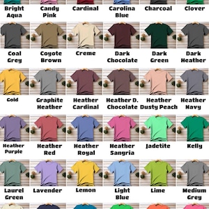 K&ouml;nnte beinhalten: Braunes T-Shirt mit Rundhalsausschnitt, pr&auml;sentiert auf Holzgrund. Die Breite des Shirts betr&auml;gt 51 cm, die L&auml;nge 74 cm. Das Bild zeigt eine Auswahl an T-Shirts in &uuml;ber 65 Farben.