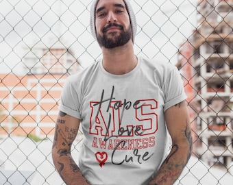 May include: White t-shirt with a red and black graphic that says "Hope ALS Love Awareness Cure". The graphic has a red heart with a black outline.