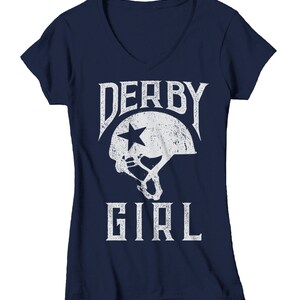 May include: Navy blue v-neck t-shirt with a white graphic of a roller derby helmet and the text "Derby Girl".