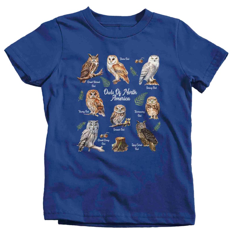 May include: A blue t-shirt with a graphic of different owls from North America. The owls are illustrated in a watercolor style and are labeled with their names. The text "Owls of North America" is printed in white on the shirt.